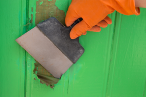 a person removing paint from their home’s walls
