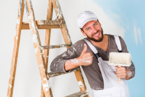 a painter smiling and giving a thumbs-up