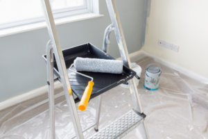 a closeup of a paint roller on a stepladder 